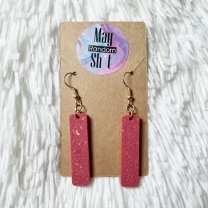 Pendientes únicos colgantes de resina opaca de color rojizo jaspeado con trazas blancas.