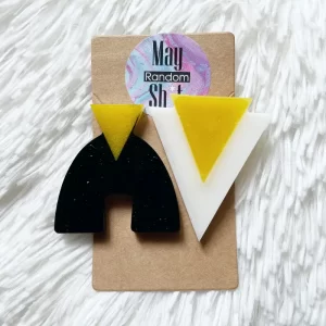 Pendientes únicos medianos y fijos de resina con piezas dobles y desparejadas de color negro, blanco y amarillo.
