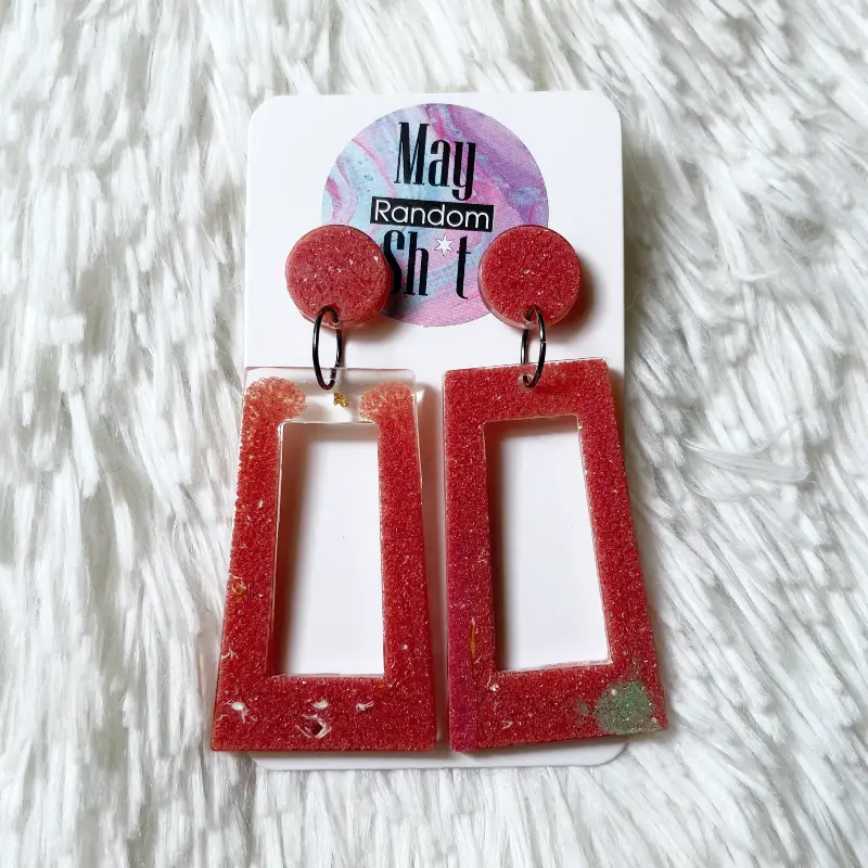 21049-anastasia Pendientes únicos de resina color rojo-teja con pequeñas trazas blancas y verdosas.