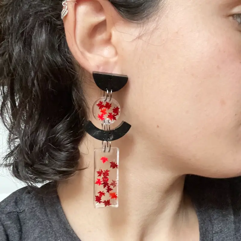 21070-ola-2 Pendientes únicos de resina transparente con hojitas rojo caoba y resina negra.