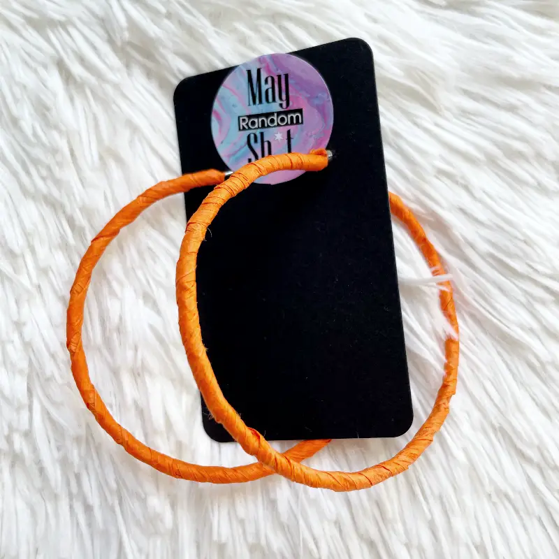 21088-aros-rafia-naran Pendientes de aro grandes plateados envueltos en rafia color naranja intenso.