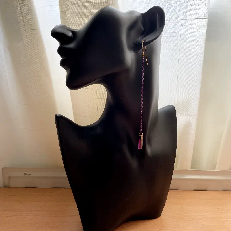 21098-violeta-1 Pendientes extra largos con cadena morada y dorada fina y una pieza rectangular pequeña de madera con resina morada.